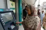 Woman using ATM for Ehsaas registration at 8171 portal.